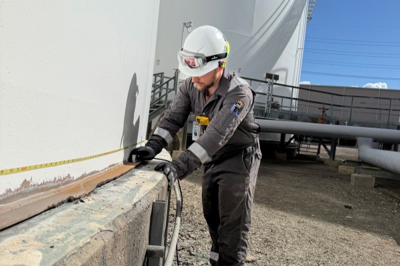 Technician scanning the annular plate from outside an in-service storage tank